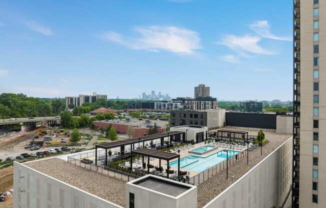 a view of the pool from the top of a building with a city in the background