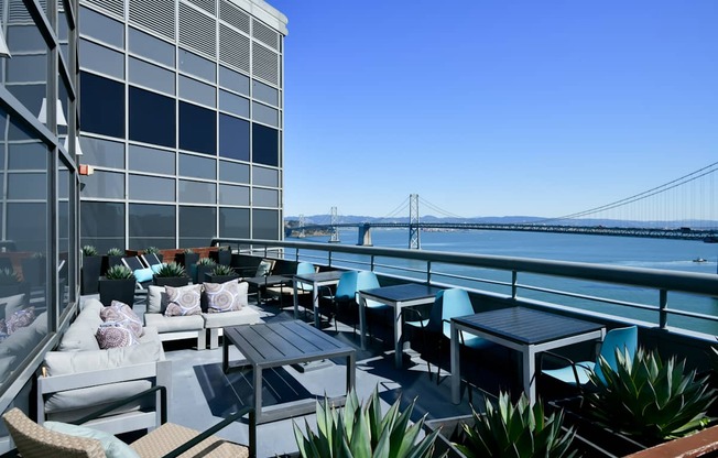 A patio with a table and chairs overlooking a bridge.