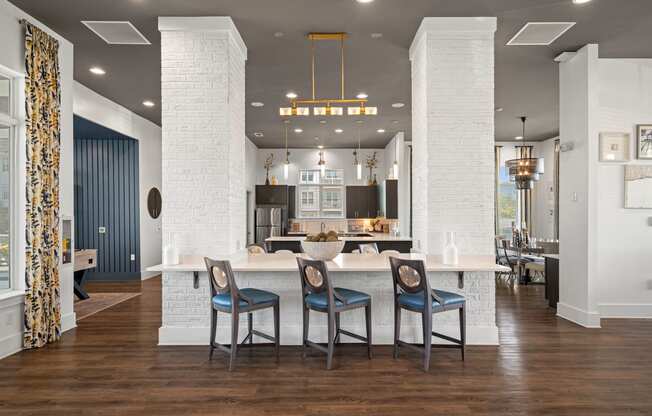 a large kitchen with a white island and blue chairs