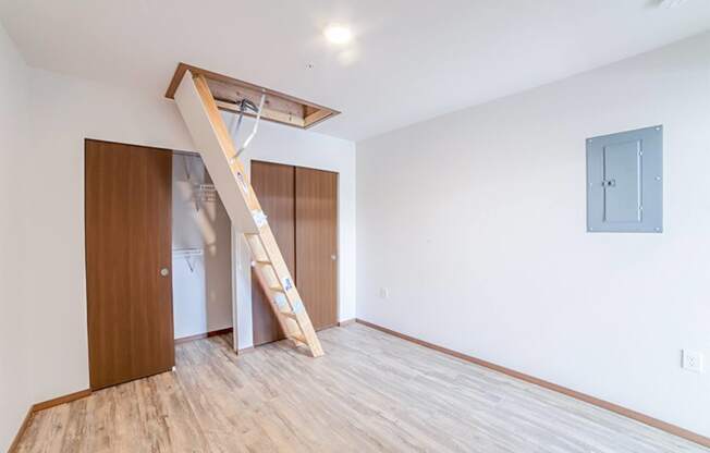 an empty room with a staircase and a wardrobe in it