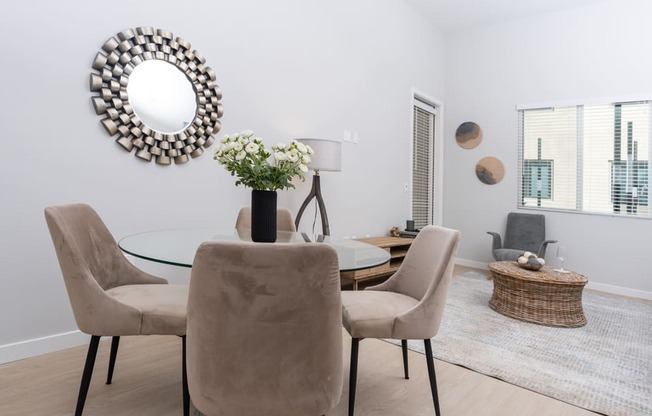 A dining room with a glass table and chairs.