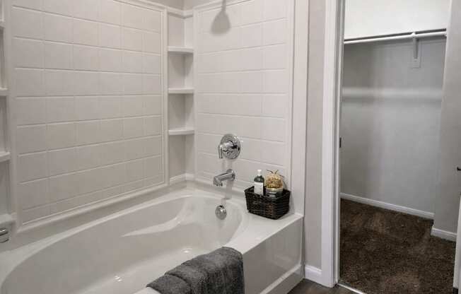 A white bathroom with a tub and a walk in shower.
