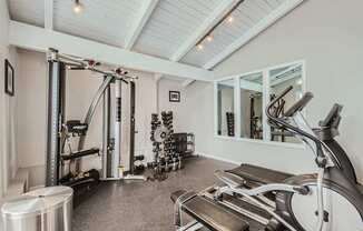 Apartments in Aurora, CO 80011 for Rent – Aurora Meadows - A spacious gym with a variety of equipment including a treadmill, a stationary bike, a rowing machine, and a weight rack.
