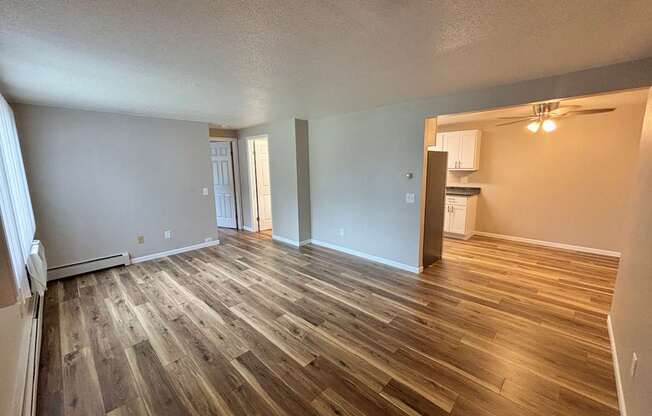 A room with wooden flooring and white walls.