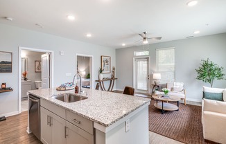 the view of a living room and a kitchen with a sink
