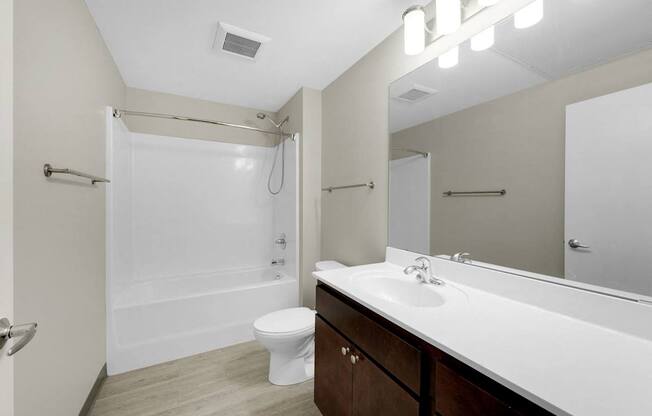 A white bathroom with a toilet, sink, and shower.