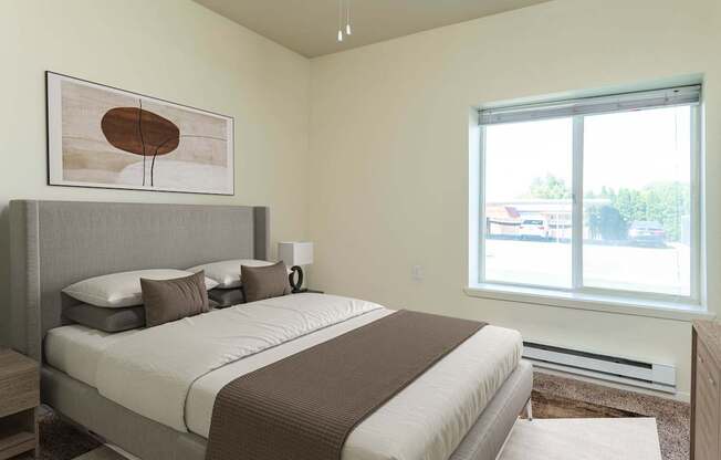 A bedroom with a large bed and a painting on the wall.