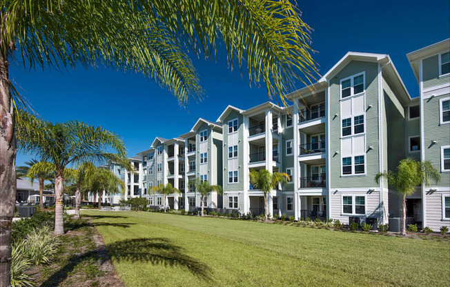 A row of modern apartment buildings with green lawns in front.