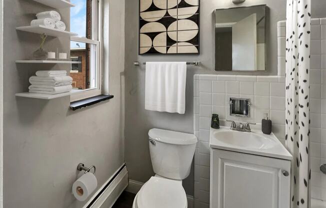 a bathroom with a toilet and a sink and a window