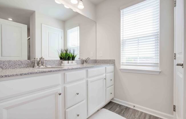 a bathroom with white cabinets and a sink and a mirror