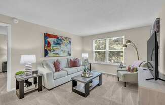 A living room with a couch, two end tables, and a television.