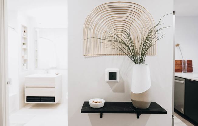 a black shelf with a vase and a plant in a bathroom at The Lively, New Jersey