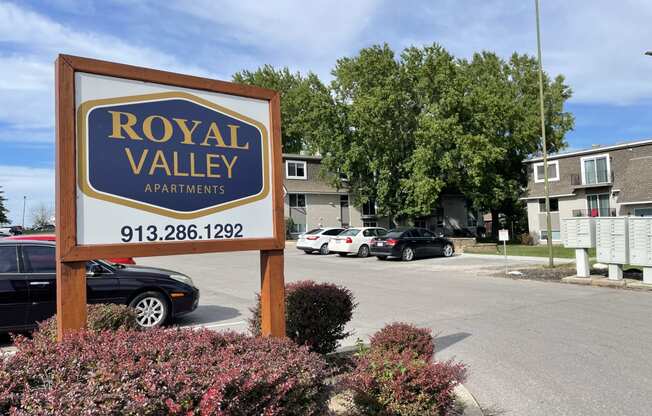 a sign for royal valley apartments in front of a parking lot