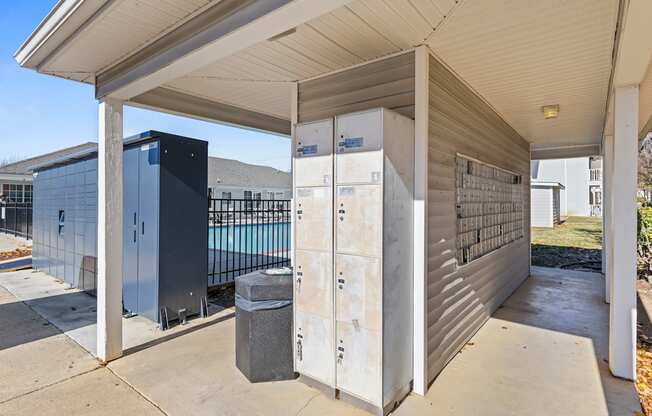 A metal storage unit is under a covered porch.