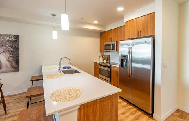 A kitchen with a white counter top and wooden cabinets.