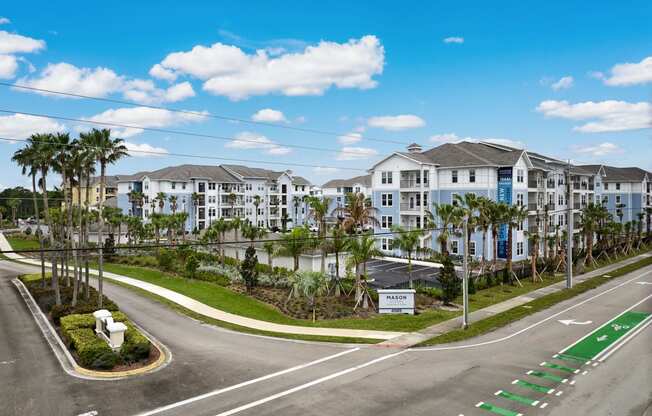 an empty street in front of a large building with palm trees