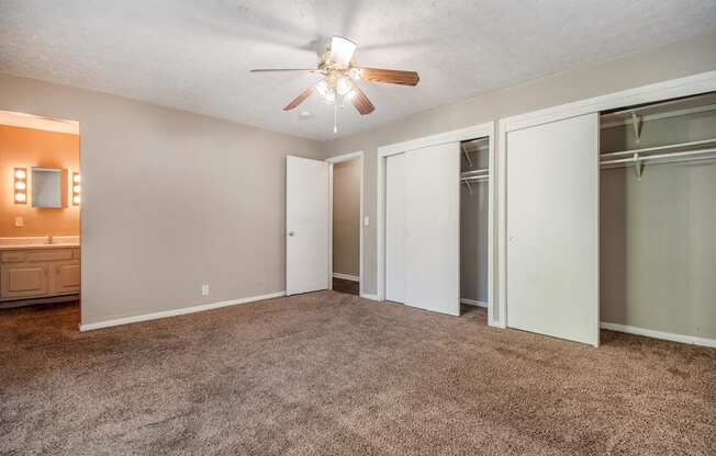 Omaha, NE Maple Ridge Apartments. A bedroom with carpeted floors and a ceiling fan