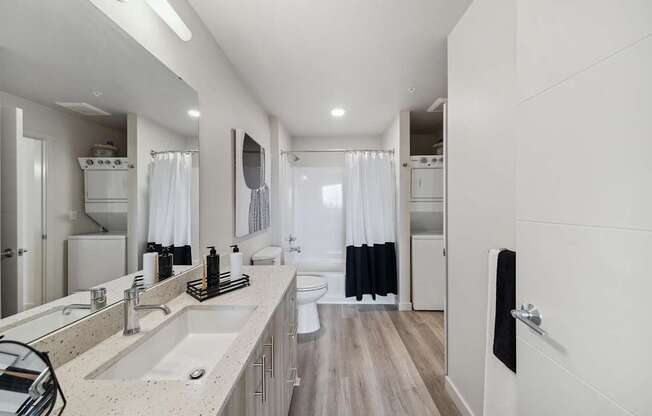 A modern bathroom with a double sink vanity and a walk-in shower.