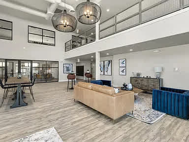 A living room with a blue sofa and a wooden floor.
