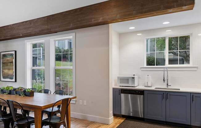 a kitchen with a table and a counter with two microwaves