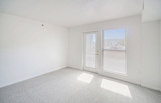 the living room with a door to a patio at Black Sand Apartment Homes in Lincoln, NE