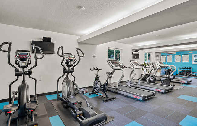 a gym with cardio machines and weights on a checkered floor