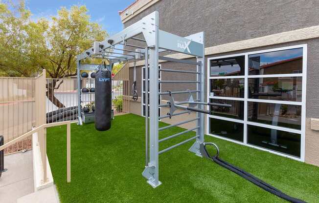 A home gym setup with a pull up bar and a punching bag.