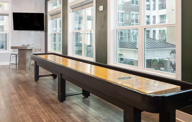 a large shuffleboard table in a room with large windows