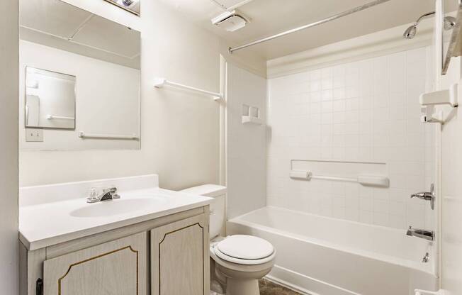 A white bathroom with a toilet, sink, and bathtub