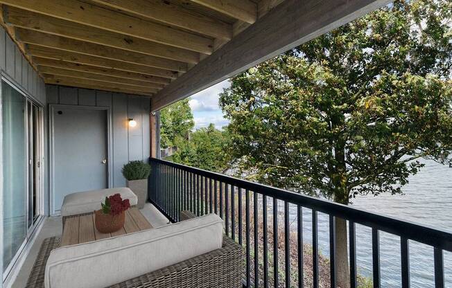 A balcony with a couch and a view of the water.