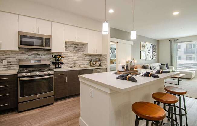 A modern kitchen with a white island and stainless steel appliances.