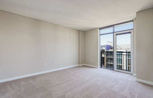 an empty living room with a balcony and a large window