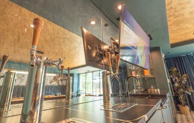 A modern bar with a stainless steel counter and a wooden tap.