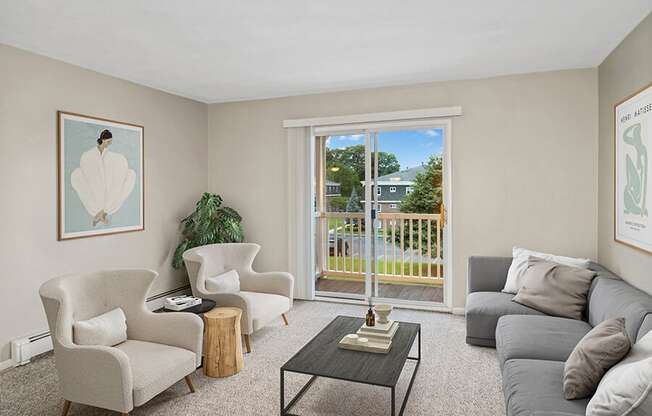 Model living room with a sliding glass door at Stone Ends apartments in Stoughton, MA