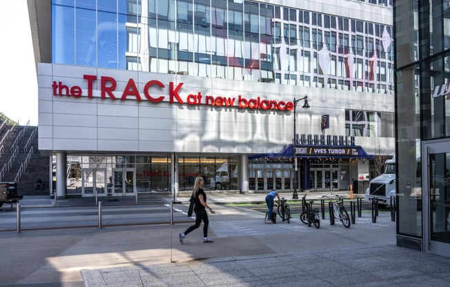 A woman walking in front of the TRACK at Boston Landing, Allston MA