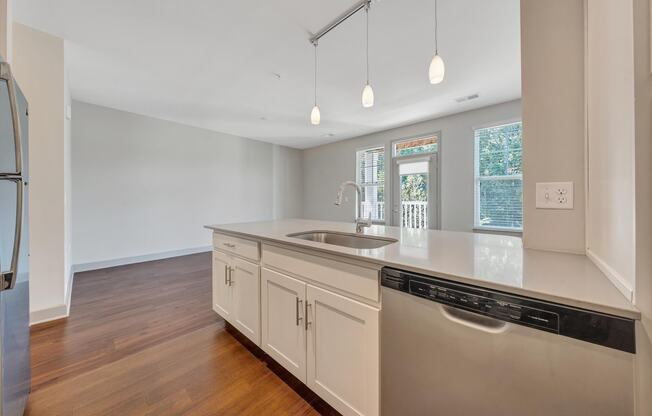 a kitchen with white cabinets and a sink and a dishwasher