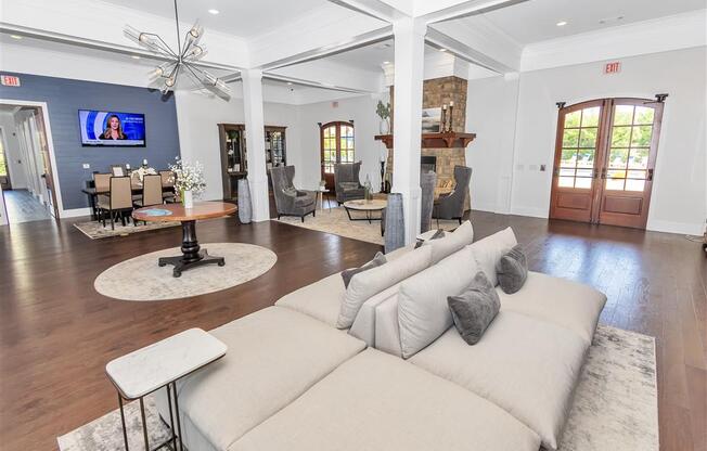 Double sided cushioned sofa in the clubhouse with a view of the fireplace and table near a TV