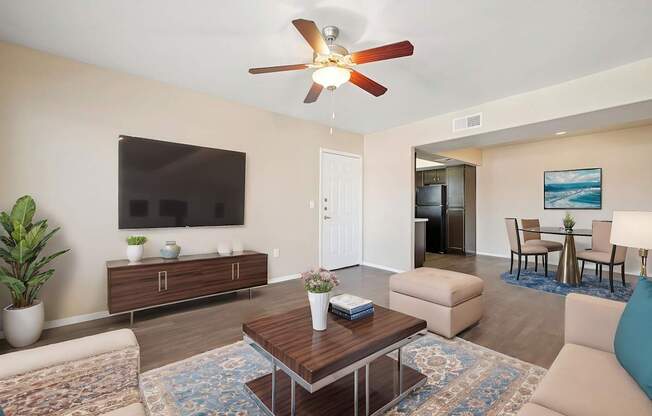 A living room with a brown coffee table and a ceiling fan.