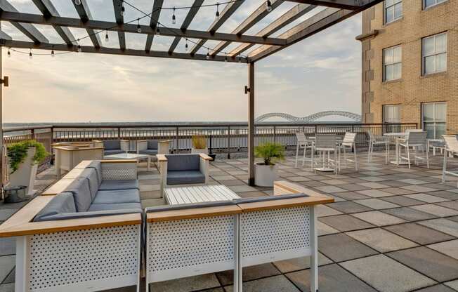 a rooftop terrace with couches and tables and a glass roof