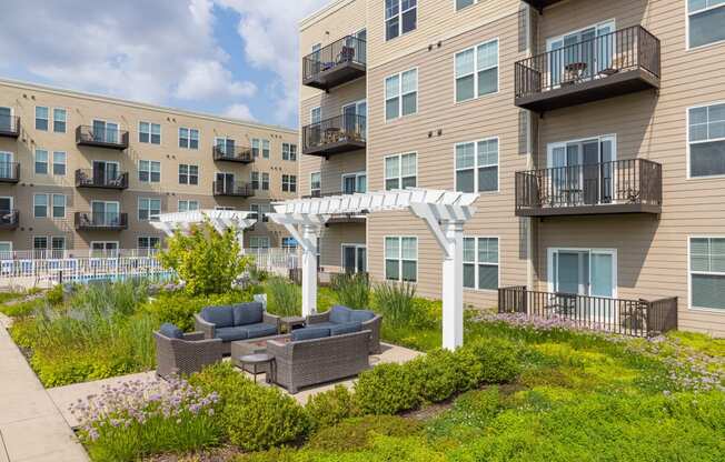 an outdoor area with a couch and a table in front of an apartment building