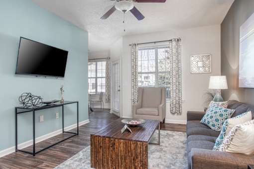 A living room with a flat screen TV mounted on the wall.