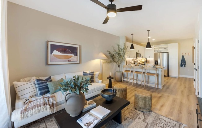 A living room with a couch, coffee table, and a ceiling fan.