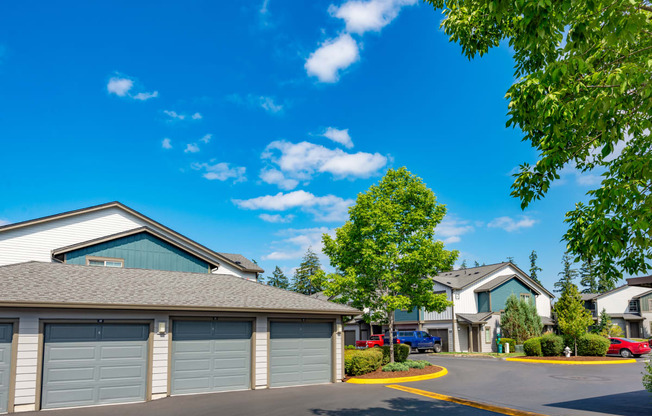 a neighborhood of garages with cars parked in front of them