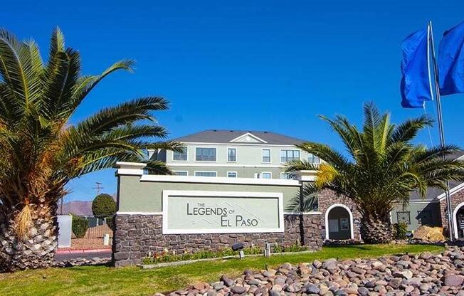 a large building with palm trees and flags in front of it