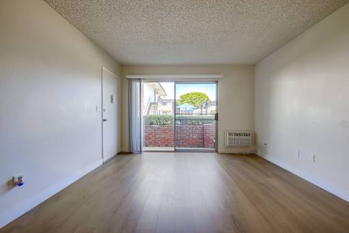 A room with a sliding glass door leading to a backyard.