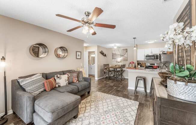 a living room with a couch and a ceiling fan