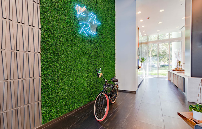 a bike parked in front of a green wall with a neon sign
