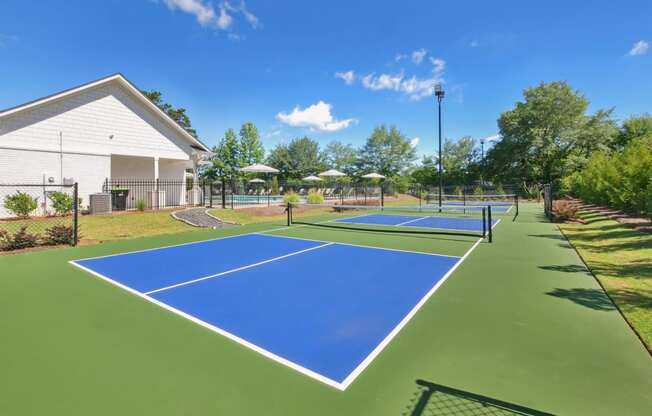 two tennis courts with umbrellas at the enclave at woodbury