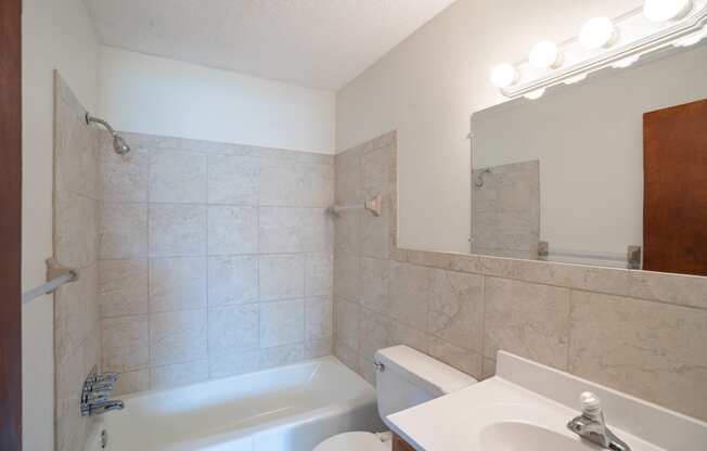 a bathroom with a sink toilet and a bath tub. Coon Rapids, MN Robinwood Apartments