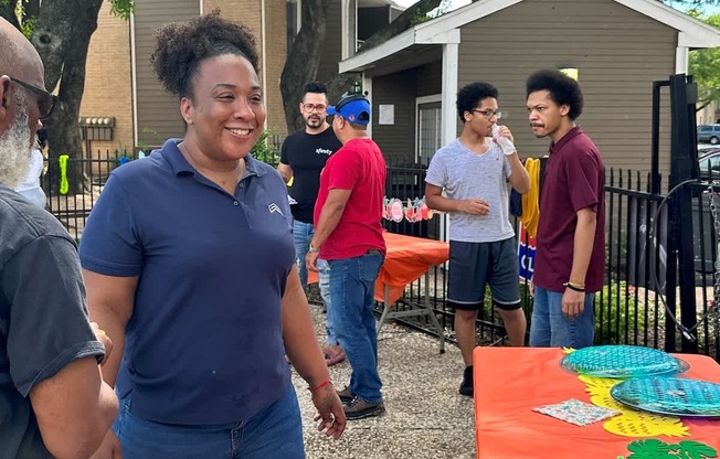 A group of people are gathered around a table with a colorful tablecloth.